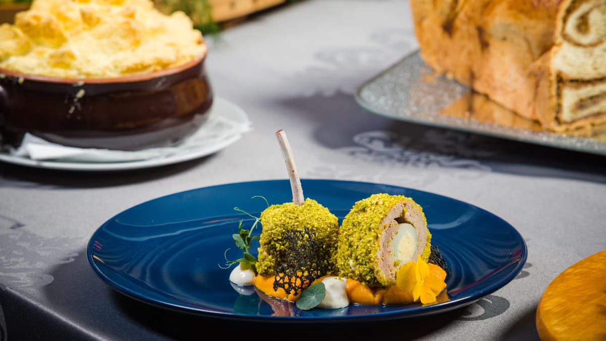 A close-up of an artfully presented gourmet dish with vibrant garnish on a blue plate.